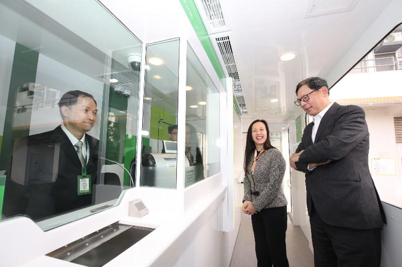 The Chief Executive of the Hong Kong Monetary Authority, Mr Norman Chan, visited a mobile branch in Hung Fuk Estate in Yuen Long and a bank branch in Kwai Shing East Estate in Kwai Chung of two retail banks today (January 12). Photo shows the Vice-chairman and Chief Executive of Hang Seng Bank, Ms Louisa Cheang (centre), introducing the design and services of the mobile branch to Mr Chan (right).