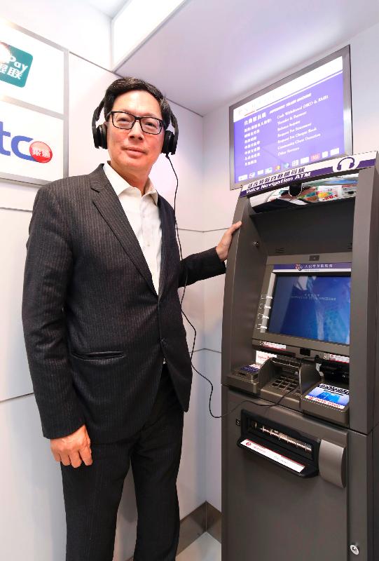 The Chief Executive of the Hong Kong Monetary Authority, Mr Norman Chan, visited a mobile branch in Hung Fuk Estate in Yuen Long and a bank branch in Kwai Shing East Estate in Kwai Chung of two retail banks today (January 12). Photo shows Mr Chan trying out a voice navigation automatic teller machine.