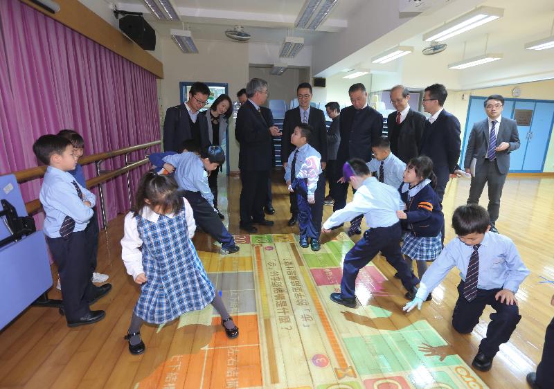 教育局局長楊潤雄（右五）今日（一月十七日）到訪觀塘聖愛德華天主教小學，並觀看同學在互動地板上進行遊戲學習。
