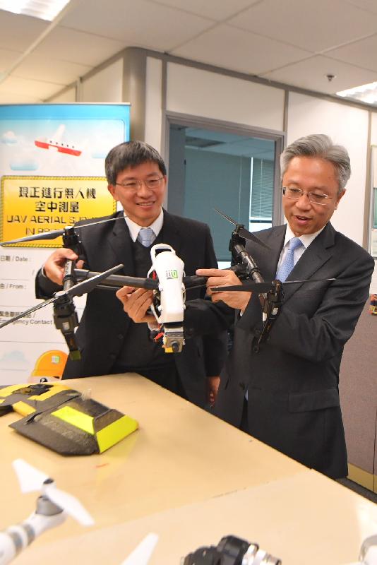 公務員事務局局長羅智光今日（一月二十五日）到訪地政總署。圖示羅智光（右）了解攝影及航空測量組如何利用無人駕駛飛行系統拍攝航空照片。旁為地政總署署長陳松青（左）。