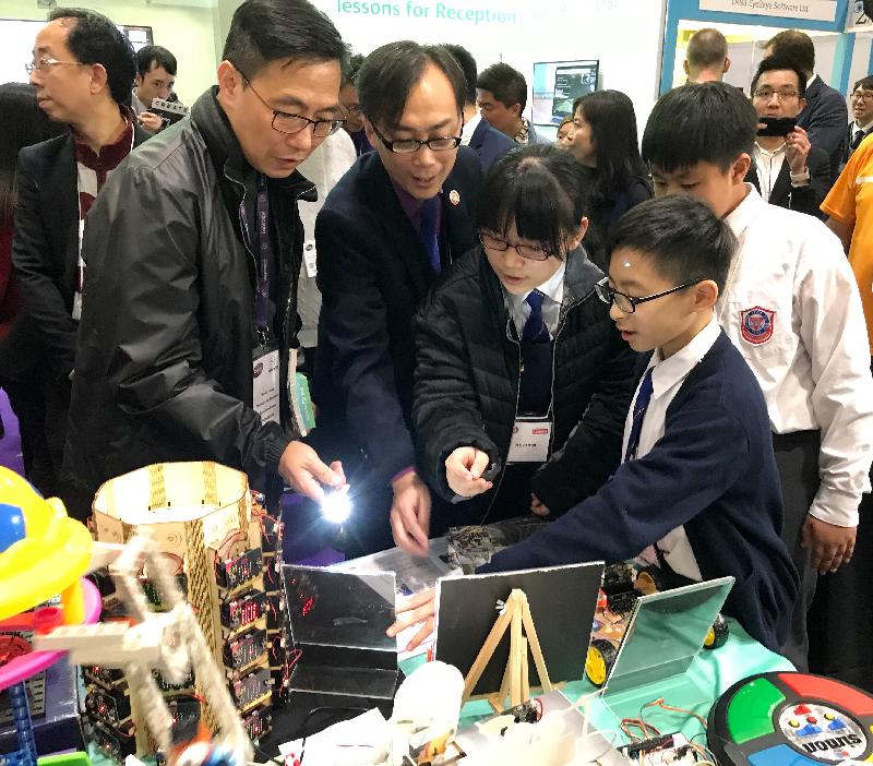The Secretary for Education, Mr Kevin Yeung (left), watches Hong Kong students demonstrating the use of their exhibits at the British Educational Training and Technology Show in London yesterday (January 24, London time).