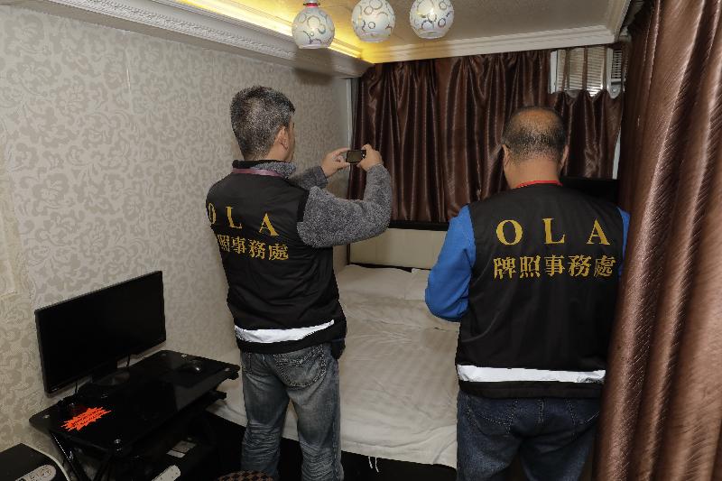The Office of the Licensing Authority (OLA) of the Home Affairs Department stepped up law enforcement actions during the Christmas and New Year holidays to combat unlicensed guesthouses. Photo shows OLA officers conducting an inspection and collecting evidence inside one of the premises.