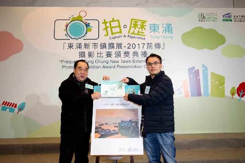 The Civil Engineering and Development Department today (February 3) held an award presentation ceremony for the “Capture and Experience Tung Chung - Prequel to Tung Chung New Town Extension 2017” photo competition. Photo shows the adjudicator and Vice President of the Photographic Society of Hong Kong, Mr Yam Shik (left), presenting the grand prize to the winner of the Open Group under the theme "Landscape, Architecture and Heritage".