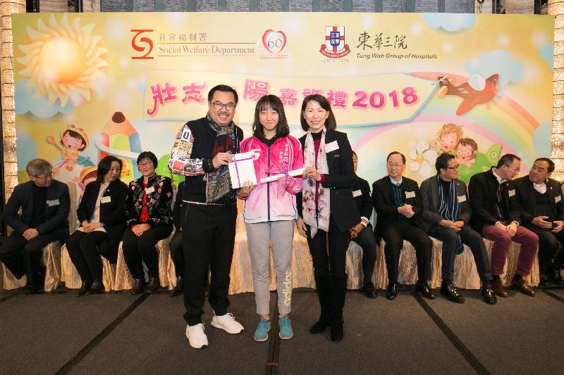 The Director of Social Welfare (DSW), Ms Carol Yip (right), and the Chairman of the Board of Directors of the Tung Wah Group of Hospitals, Dr Lee Yuk-lun (left), present a certificate to a DSW ward (centre) with outstanding achievements at the 2018 Award Presentation Ceremony for DSW wards today (February 3).