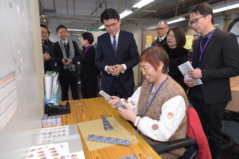  商務及經濟發展局局長邱騰華（左四）今日（二月六日）到訪郵政總局，觀看香港郵政職員處理郵票產品。