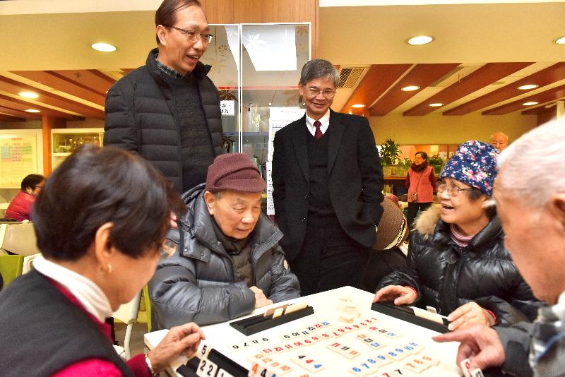 The Secretary for Labour and Welfare, Dr Law Chi-kwong, visited Caritas Cheng Shing Fung District Elderly Centre (Sham Shui Po) today (February 6). Photo shows Dr Law (right), accompanied by the Senior Social Work Supervisor of Services for the Elderly of Caritas Hong Kong, Mr Lai Sau-man (left), watching elderly people playing a board game.