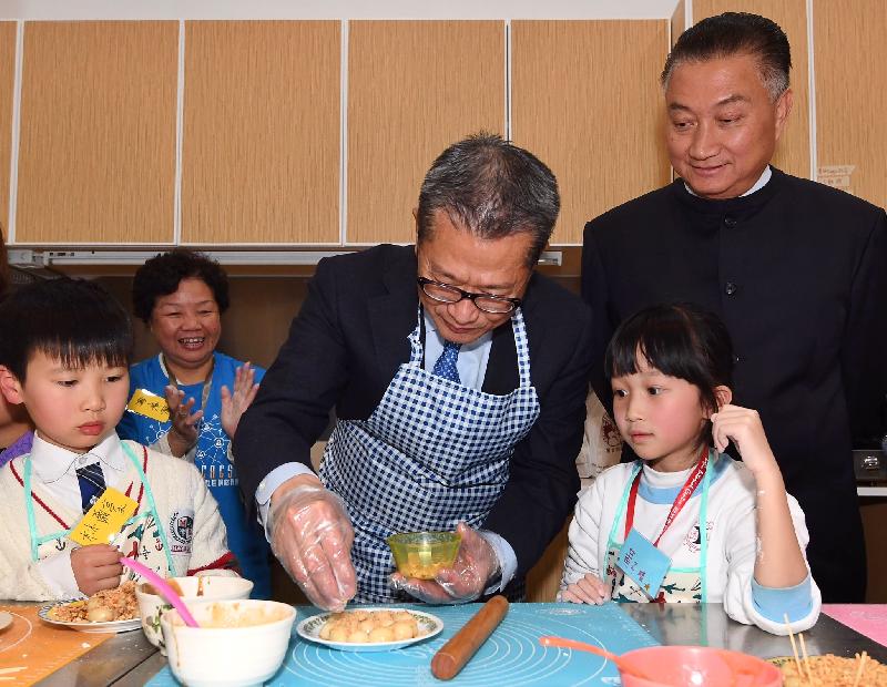 財政司司長陳茂波（左三）今日（二月七日）在觀塘區議會主席陳振彬博士（右一）陪同下，參觀香港基督教服務處觀塘樂Teen會，並與中心內的兒童製作賀年小食。