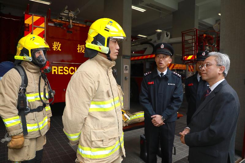The Secretary for the Civil Service, Mr Joshua Law, visited the Fire Services Department today (February 9). Photo shows Mr Law (first right) being briefed on the personal protective equipment of a fireman.