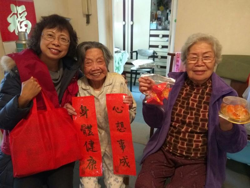 The Housing Department (HD) Volunteers Corps visited elderly tenants at Ming Tak Estate, Tseung Kwan O, last Saturday (February 10). Photo shows a member of the HD Volunteers Corps giving elderly tenants festive gifts.
