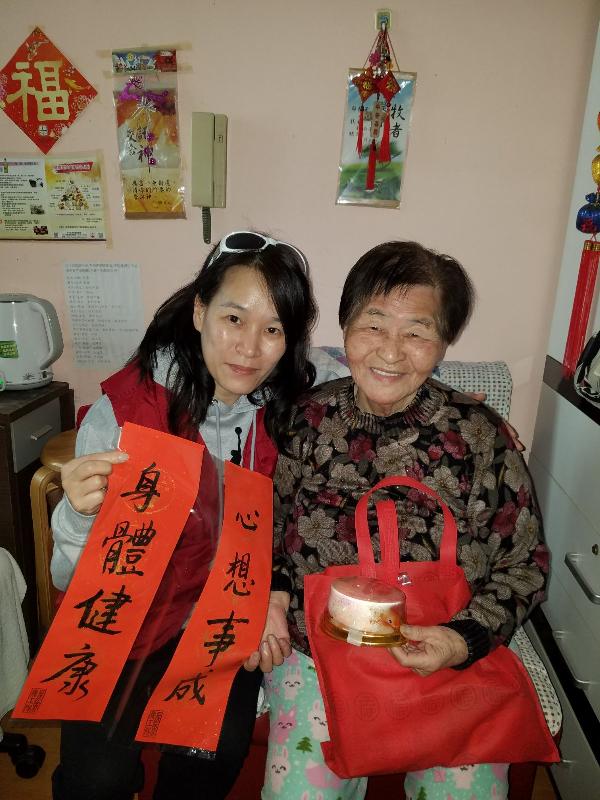 The Housing Department (HD) Volunteers Corps visited elderly tenants at Ming Tak Estate, Tseung Kwan O, last Saturday (February 10). Photo shows a member of the HD Volunteers Corps giving an elderly tenant festive gifts.