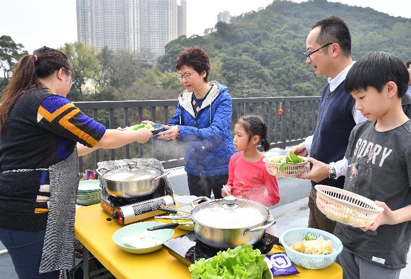 The Chief Executive, Mrs Carrie Lam, attended a New Year Feast this afternoon (February 25) with dozens of residents of the Light Housing project in Sham Tseng to extend her Chinese New Year greetings to them. Picture shows Mrs Lam (fourth right) enjoying a hot pot meal with the residents on the rooftop where they hold gatherings frequently.

