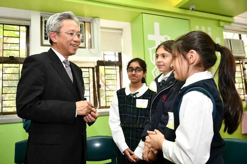 The Secretary for the Civil Service, Mr Joshua Law, visited Kwai Tsing District today (February 27). Photo shows Mr Law (left) chatting with non-ethnic-Chinese students at Asbury Methodist Social Service to learn more about their learning experiences.
