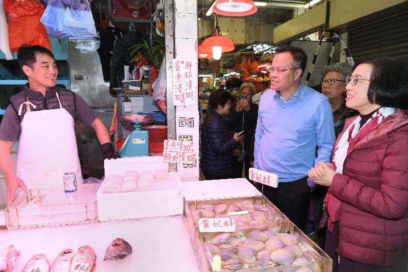 The Secretary for Food and Health, Professor Sophia Chan (first right), inspects Tai Wai Market today (March 9) and chats with stall tenants to learn about their operations.