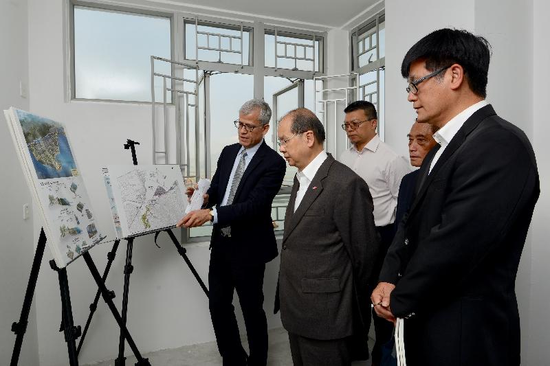 The Chief Secretary for Administration, Mr Matthew Cheung Kin-chung (second left), receives a briefing from the concerned government department on the latest developments in Tung Chung and nearby areas during his visit to Ying Tung Estate today (March 15). Also joining is the Chairman of the Islands District Council, Mr Chow Yuk-tong (second right).