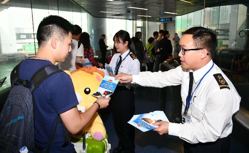 Marine inspectors of the Marine Department distribute promotional leaflets to passengers in the waiting lounge of the Hong Kong-Macau Ferry Terminal in Sheung Wan today (March 16) to encourage them to fasten their seat belts at the appropriate time to ensure a safe journey.