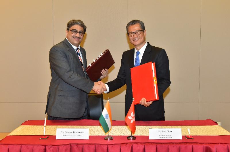 財政司司長陳茂波（右）和印度駐華大使Gautam Bambawale（左）今日（三月十九日）在簽署全面性避免雙重課稅協定後交換文件。