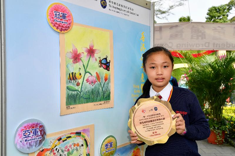 The annual spectacular Hong Kong Flower Show at Victoria Park will close at 9pm tomorrow (March 25). The Jockey Club Student Drawing Competition had its prize presentation ceremony today (March 24) and winning entries are now on display at the showground. Photo shows the champion of the Junior Section in Primary School, Kwan Ding-wai, and her winning entry.
