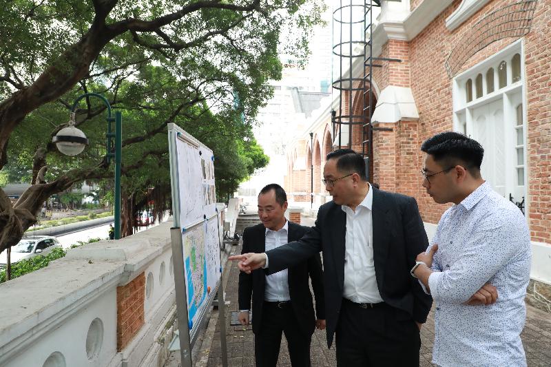 The Secretary for Innovation and Technology, Mr Nicholas W Yang (centre), receives a briefing by the Assistant Government Chief Information Officer (Industry Development), Mr Tony Wong (left), on the Smart Lampposts pilot scheme, and inspects a proposed section along Nathan Road where such lampposts will be  installed, during his visit to Yau Tsim Mong District today (March 26). Next to Mr Yang is the Chairman of the Yau Tsim Mong District Council, Mr Chris Ip (right).