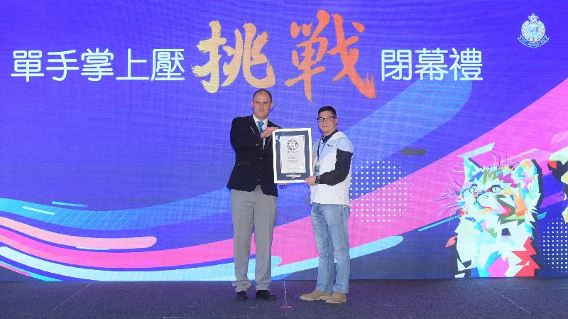 The adjudicator of Guinness World Records, Mr John Garland (left), presenting a certificate to Police Director of Operations, Mr Tang Ping-keung.