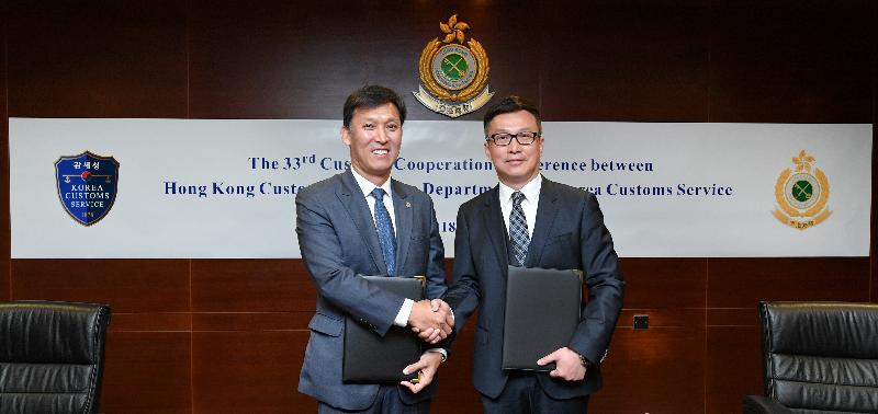 香港海关关长邓以海（右）和韩国关税厅厅长金荣文（左）今日（四月十日）签订中国－－韩国自由贸易协定有关原产地管理的合作及互助备忘录后交换文件。