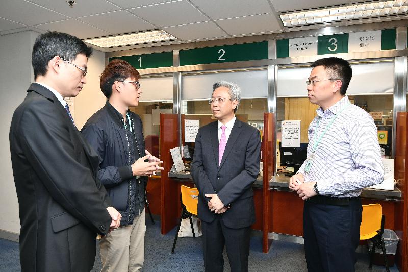 The Secretary for the Civil Service, Mr Joshua Law, visited the Working Family and Student Financial Assistance Agency (WFSFAA) today (April 11). Photo shows Mr Law (second right), accompanied by the Head of the WFSFAA, Mr Esmond Lee (first left), being briefed by front-line staff on their daily work at the Counter Service Unit of the Student Finance Office.