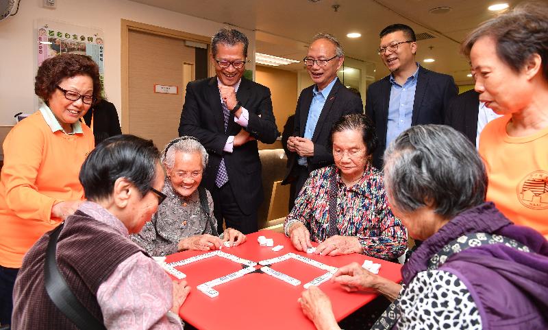 The Financial Secretary, Mr Paul Chan (back row, second left), today (April 20) meets with the elderly at the Tung Chung Integrated Services Centre of the Neighbourhood Advice-Action Council. He is accompanied by the Acting Executive Director of the Neighbourhood Advice-Action Council, Mr Tai Keen-man (back row, third left), and the Vice-chairman of the Islands District Council, Mr Randy Yu (back row, fourth left).