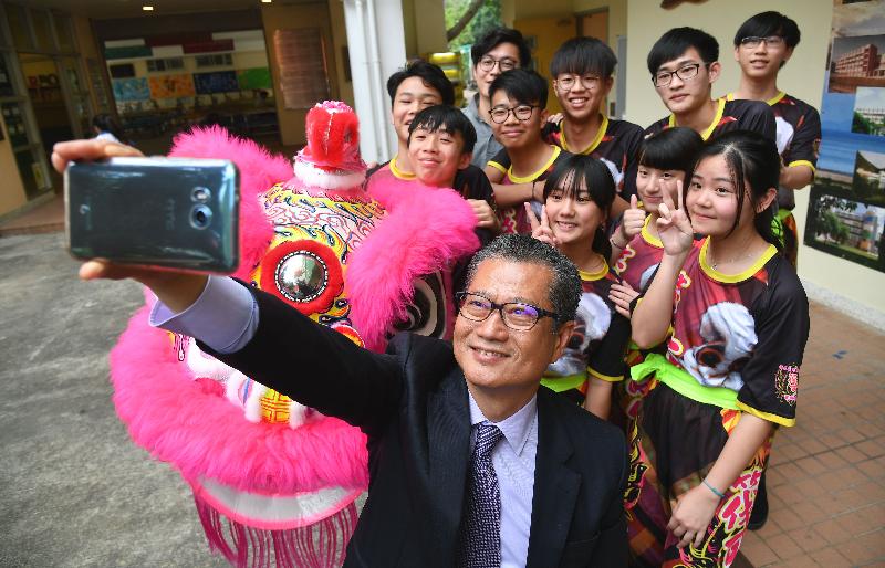 The Financial Secretary, Mr Paul Chan, today (April 20) visited Buddhist Fat Ho Memorial College in Tai O and watched students' talent performances. Photo shows Mr Chan taking a photo with the lion dance team.