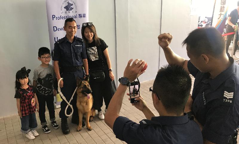 Visitors taking photos with a dog handler from the Police Dog Unit