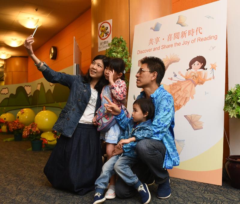 To encourage members of the public to discover and share the joy of reading and to tie in with World Book Day, the Hong Kong Public Libraries of the Leisure and Cultural Services Department held a series of vibrant activities, including the Fun at Central Library fun day, at the Hong Kong Central Library today (April 22). Photo shows visitors taking photos with an image of the mascot which was specially designed for the reading-for-all campaign, themed "Discover and Share the Joy of Reading".