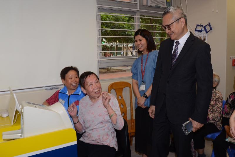 The Under Secretary for Food and Health, Dr Chui Tak-yi (right), chats with users of the Caritas Elderly Centre - Tung Tau today (April 23).


