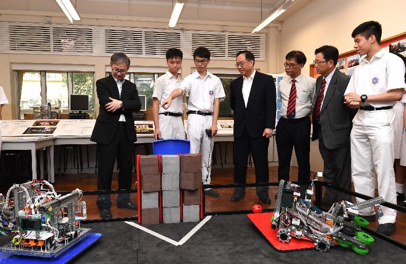創新及科技局局長楊偉雄（中）今日（四月三十日）探訪香港培正中學，觀看同學示範在科技挑戰賽香港區選拔賽中的參賽機械人。