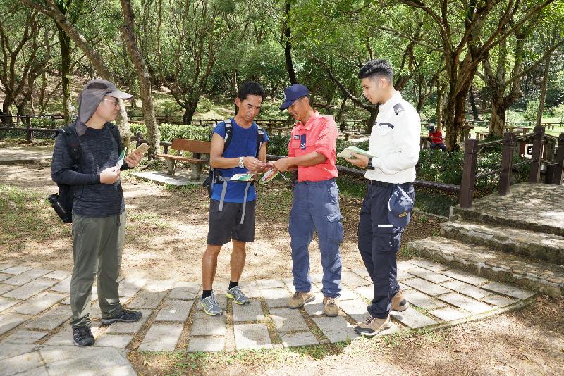 Members of the Civil Aid Service and personnel of the Agriculture, Fisheries and Conservation Department distribute mountaineering safety promotional materials to hikers.