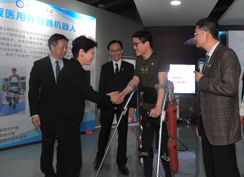  The Chief Executive, Mrs Carrie Lam, visited the University of Electronic Science and Technology of China (UESTC) in Chengdu this morning (May 12). Photo shows Mrs Lam (second left) greeting the person with disabilities using the assistive device (second right). Looking on are the Secretary for Constitutional and Mainland Affairs, Mr Patrick Nip (centre), and the Party Secretary of UESTC, Mr Wang Yafei (first left).