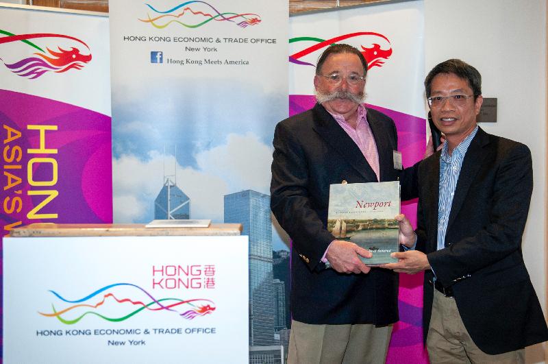 新港市市長Henry F. Winthrop（左）於五月十三日（羅德島州新港時間）在香港駐紐約經濟貿易辦事處舉辦的歡迎酒會上呈送一本關於新港市的書予香港駐美國總經濟貿易專員梁卓文。