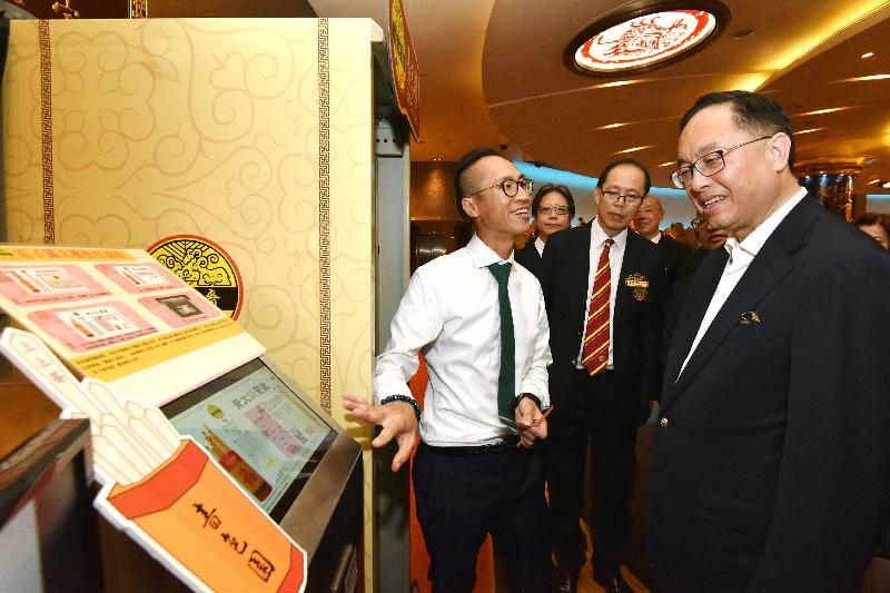 The Secretary for Innovation and Technology, Mr Nicholas W Yang (right), is introduced to Sik Sik Yuen's e-Charm Management System during his visit to Wong Tai Sin Temple today (May 17).