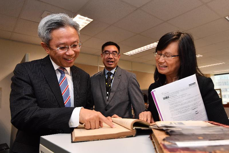 公务员事务局局长罗智光今日（五月十八日）到访库务署。图示罗智光（左一）浏览在上世纪初用作记录领取退休金人士资料的册子。