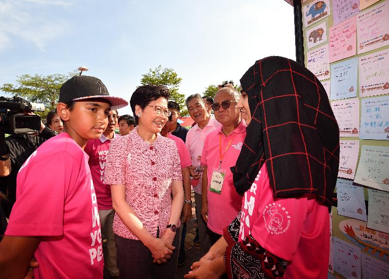 The Chief Executive, Mrs Carrie Lam, attended the Tsuen Wan Dragon Boat Race 2018 at the Tsuen Wan Promenade this afternoon (June 3). Photo shows Mrs Lam (second left) touring the stall of Hong Kong Children and Youth Services and chatting with ethnic minority youths.