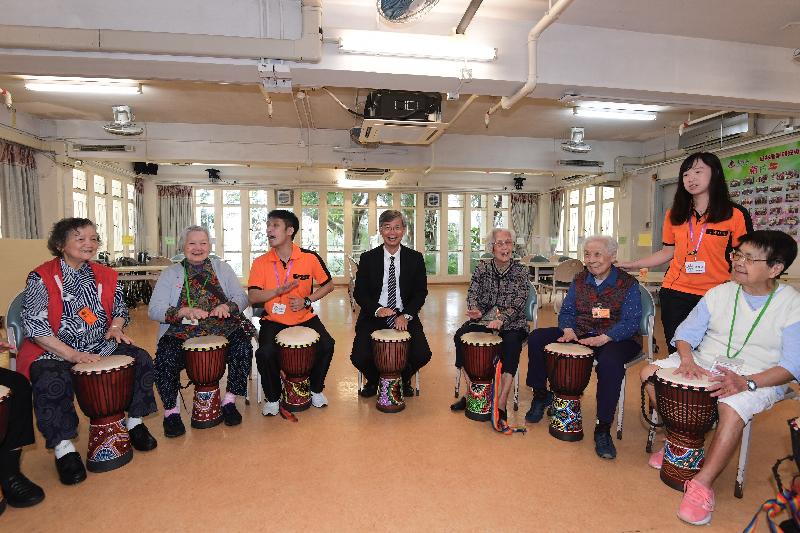 The Secretary for Labour and Welfare, Dr Law Chi-kwong, visited Tai Po District and elderly residents in TWGHs Pao Siu Loong Care & Attention Home today (June 5). Photo shows Dr Law (centre) playing African drums with the elderly.