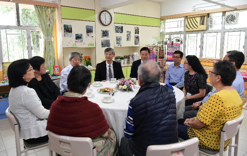 The Secretary for Labour and Welfare, Dr Law Chi-kwong, visited Tai Po District and elderly residents in TWGHs Pao Siu Loong Care & Attention Home today (June 5). Photo shows Dr Law (centre) discussing the small group unit model of the institution with residents and their families.