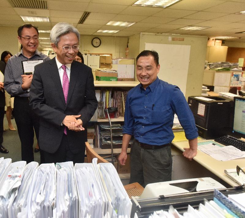 The Secretary for the Civil Service, Mr Joshua Law, visited the Home Affairs Department today (June 6). Photo shows Mr Law (centre) chatting with a clerical staff member of the Wan Chai District Office to learn more about his daily work.