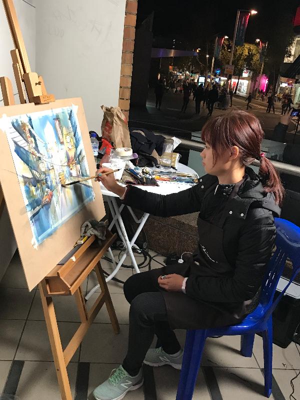 With the support of the Hong Kong Economic and Trade Office, Sydney, young Hong Kong watercolour artist Elaine Chiu has been painting pictures of future cities and space live for spectators at a Vivid Sydney event in the Chatswood district of Sydney, Australia. Photo shows Chiu painting in Chatswood.