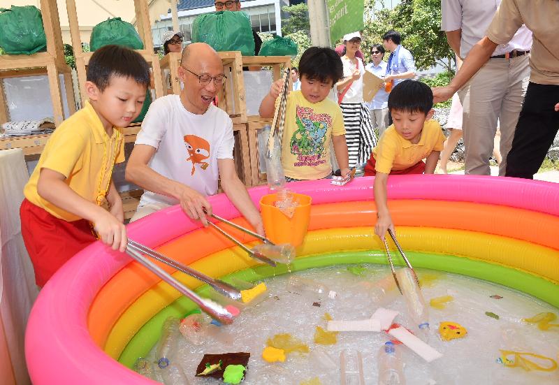The Secretary for the Environment, Mr Wong Kam-sing (second left), tours a game booth after the opening ceremony of the "World Environment Day 2018 • Zero Waste Fun Fair" held at the Zero Carbon Building in Kowloon Bay today (June 10).