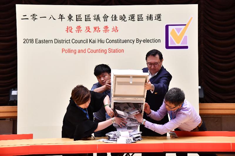 The Electoral Affairs Commission Chairman, Mr Justice Barnabas Fung Wah (second right), empties a ballot box at the counting station at Siu Sai Wan Community Hall for the by-election in the Kai Hiu Constituency of the Eastern District Council last night (June 10). 
