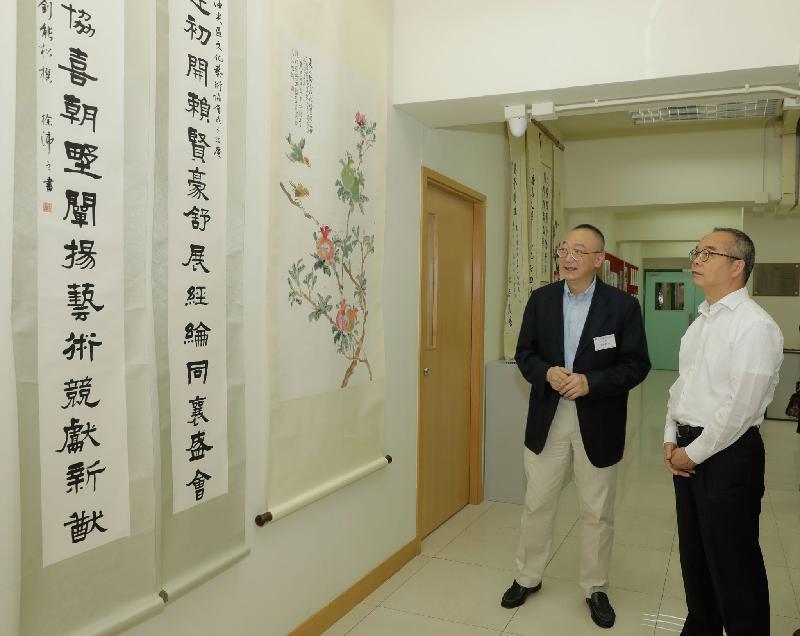 The Secretary for Home Affairs, Mr Lau Kong-wah (right), visits the Yau Ma Tei and Tsim Sha Tsui Culture and Arts Association and admires its members' paintings and calligraphy when visiting Yau Tsim Mong District today (June 11).