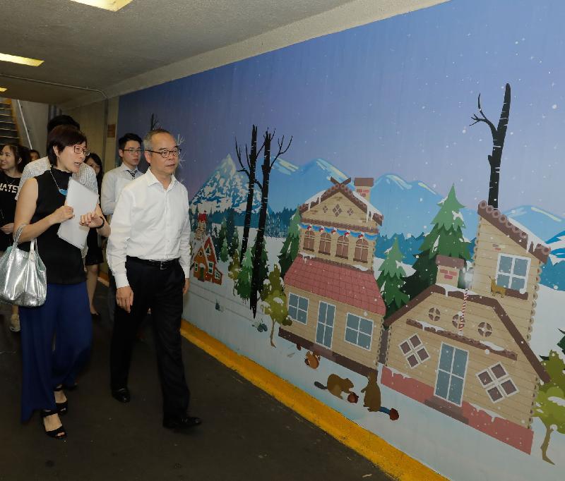 The Secretary for Home Affairs, Mr Lau Kong-wah (right), tours the Soy Street pedestrian subway to inspect the wall sticker beautification work during his visit to Yau Tsim Mong District today (June 11).