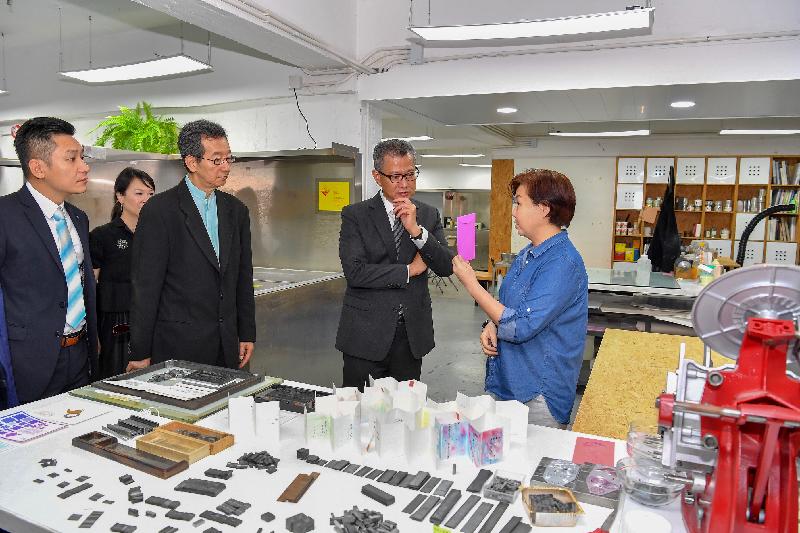 The Financial Secretary, Mr Paul Chan (second right), accompanied by the Chairman of the Sham Shui Po District Council, Mr Ambrose Cheung (third right), and the District Officer (Sham Shui Po), Mr Damian Lee (first left), visits the Jockey Club Creative Arts Centre today (June 13) and meets with an artist there.