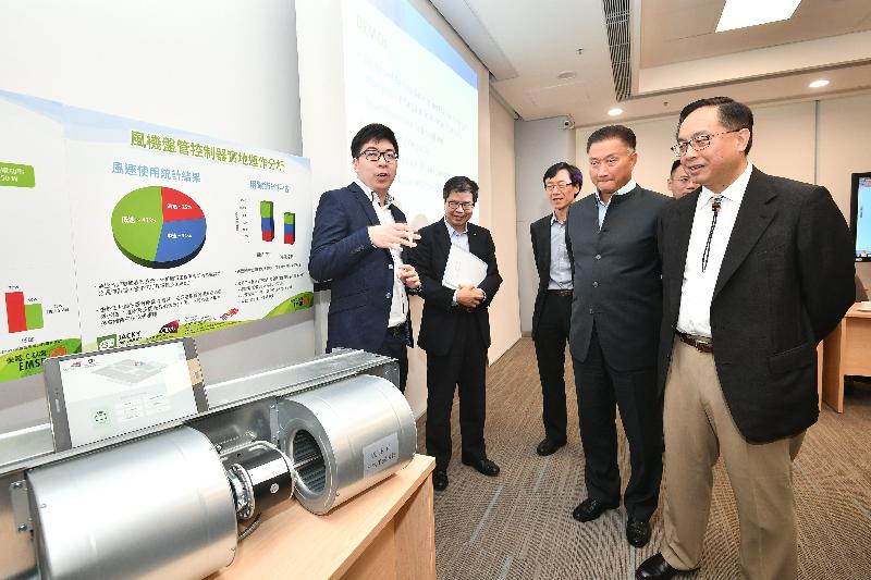 創新及科技局局長楊偉雄（右一）今日（六月十四日）參觀機電工程署總部，了解由香港城市大學團隊研發的智能溫度調節器。該項目獲得大學科技初創企業資助計劃支持，適用於中央冷氣系統。