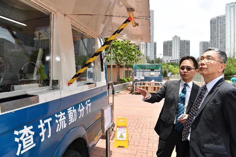 The Secretary for Financial Services and the Treasury, Mr James Lau (right), tours Standard Chartered Bank's mobile branch at Yan On Estate today (June 19) to understand the services it provides.