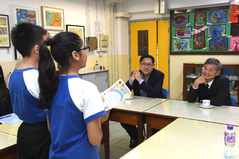 The Secretary for Labour and Welfare, Dr Law Chi-kwong, visited Kowloon City District today (June 22) and called at Po Leung Kuk Madam Chan Wai Chow Memorial School. Photo shows Dr Law (first right), accompanied by the District Officer (Kowloon City), Mr Franco Kwok (second right), listening to pupils sharing details of the initiation programme they are studying.