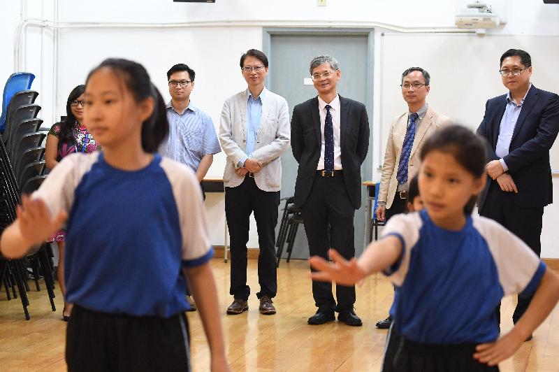 The Secretary for Labour and Welfare, Dr Law Chi-kwong, visited Kowloon City District today (June 22) and called at Po Leung Kuk Madam Chan Wai Chow Memorial School. Photo shows (back row, from second left) the Vice Chairman of Kowloon City District Council (KCDC), Mr Cho Wui-hung; the Chairman of KCDC, Mr Pun Kwok-wah; Dr Law; the Principal of the school, Mr Chan Kin-hung; and the District Officer (Kowloon City), Mr Franco Kwok, watching pupils doing rehearsals for their graduation ceremony.